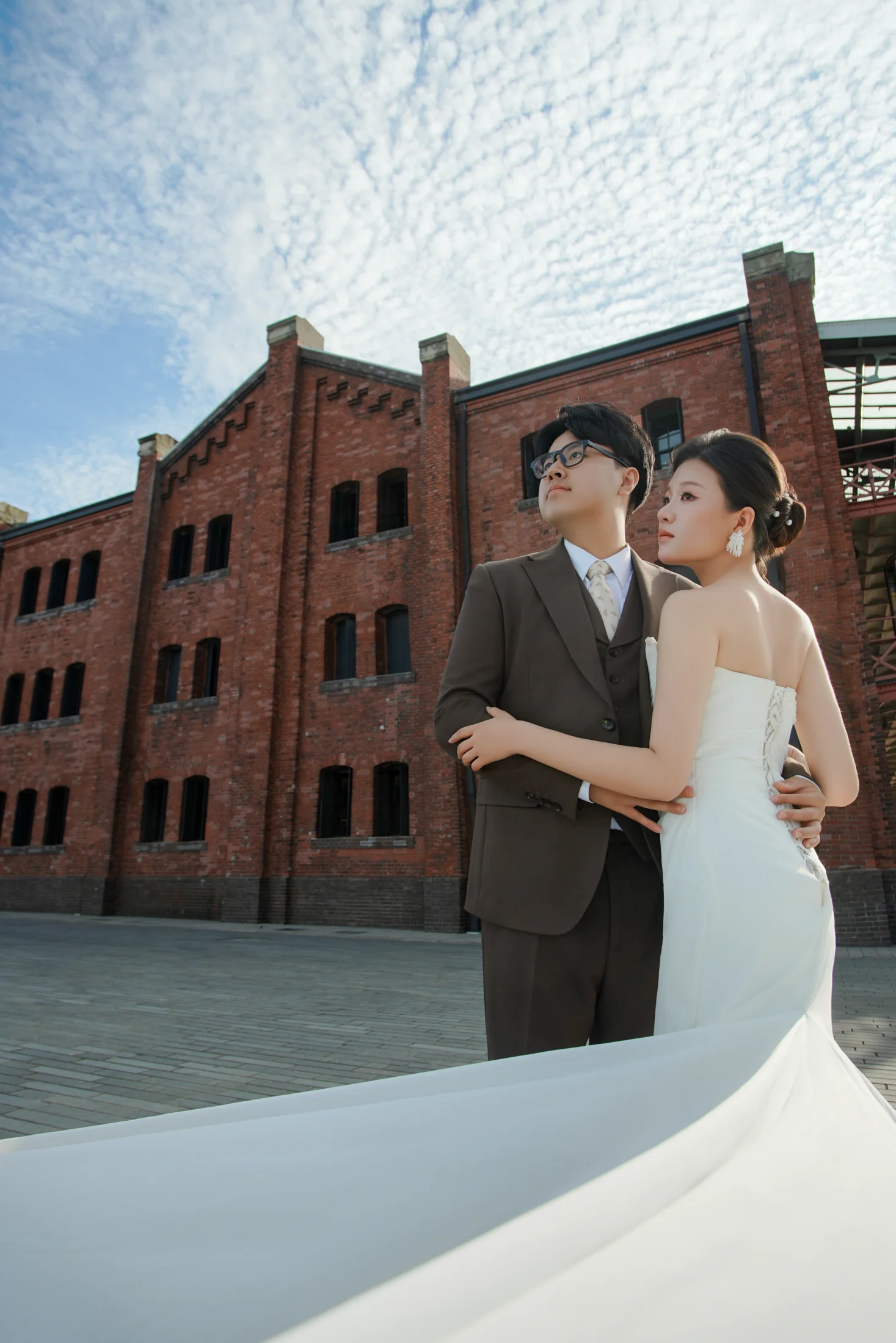 红砖建筑前的婚纱与两人